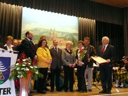 Bürgermeister Schuler, Gemeinderäte und Ehrenbürger Gottfried Rohrer stehen auf der Bühne